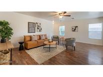 Bright living room featuring a modern tan leather sofa, ceiling fan, and stylish decor at 4642 E Sierrita Rd, San Tan Valley, AZ 85143
