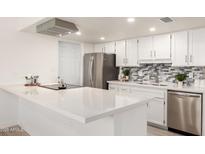 Bright kitchen features white cabinets, stainless steel appliances, and quartz countertops at 5243 W Vernon Ave, Phoenix, AZ 85035