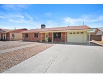 Charming single story home with a red brick facade, spacious driveway and covered porch area at 724 N Pine St, Gilbert, AZ 85233