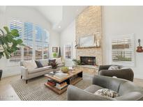 Bright living room with a stone fireplace, large windows, and comfortable seating area, creating a cozy atmosphere at 1285 E Horseshoe Ave, Gilbert, AZ 85296