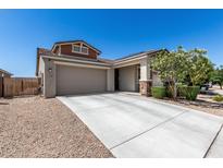 Charming single-Gathering home boasts desert landscaping, a two-car garage, and a covered porch with stone accents at 17171 W Tonto St, Goodyear, AZ 85338