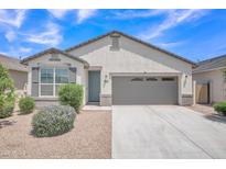 Charming single-story home with desert landscaping, gray trim, and a two-car garage at 38150 W San Sisto Ave, Maricopa, AZ 85138