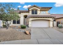 Inviting home featuring a neutral color palette, two-car garage, and well-maintained desert landscaping at 4449 E Rancho Caliente Dr, Cave Creek, AZ 85331