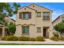Charming two-story home featuring a decorative wrought iron balcony and colorful yellow flowering bushes at 4853 S Charger --, Mesa, AZ 85212