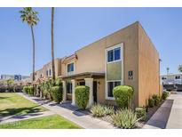 Charming condo exterior with manicured lawn, mature landscaping, and desert plants near the building at 601 E Palo Verde Dr # 27, Phoenix, AZ 85012