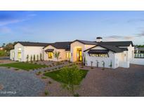 Stunning luxury home with a manicured lawn and elegant stone accents at twilight at 6147 E Desert Cove Ave, Scottsdale, AZ 85254