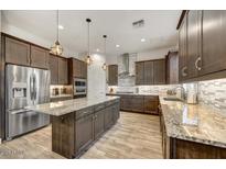 Modern kitchen with stainless steel appliances, granite countertops and a central island with pendant lighting at 6503 E Bluefield Ave, Phoenix, AZ 85054