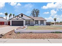 Charming single-story home with manicured lawn, attached garage, and neutral color palette at 6863 W Sunnyside Dr, Peoria, AZ 85345