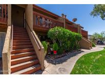 Charming condo exterior featuring wood railings, desert landscaping, and a well-maintained walkway at 14203 N 19Th Ave # 2036, Phoenix, AZ 85023