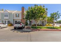 Inviting townhouse featuring a brick chimney, front yard landscaping, and off-street parking at 1600 N Saba St # 143, Chandler, AZ 85225