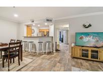 Open-concept living room with breakfast bar and wood-look flooring, ready for entertaining and comfortable living at 2025 E Campbell Ave # 107, Phoenix, AZ 85016