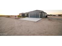 Charming single-story home featuring a modern garage door design and desert landscaping at 22548 W Huntington Dr, Buckeye, AZ 85326