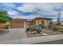 Charming single-story home boasts a well-manicured desert landscape with colorful flowering bushes at 3522 W Rushmore Dr, Anthem, AZ 85086