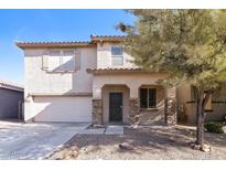 Two-story home with desert landscaping, covered porch with stone accents, and a two car garage at 42564 W Palmyra Ln, Maricopa, AZ 85138