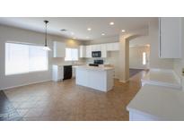Bright kitchen features tile floors, white cabinets, and a center island at 44092 W Stonecreek Rd, Maricopa, AZ 85139
