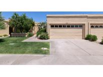 Attached beige garage with two bays and a well-manicured green lawn at 5505 E Mclellan Rd # 111, Mesa, AZ 85205