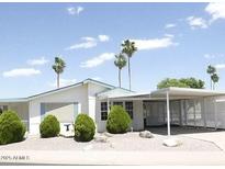 Charming single-story home with manicured landscaping, carport and tall palm trees in the front yard at 5808 E Lockwood St, Mesa, AZ 85215