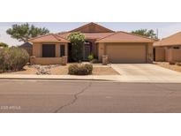 Charming single-story home with a well-manicured, low-maintenance desert landscape and tile roof at 7701 E Portobello Ave, Mesa, AZ 85212