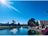 Scenic view of a pond with fountains, surrounded by landscaping and condominium buildings at 7960 E Camelback Rd # 109, Scottsdale, AZ 85251