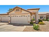 Beige one-story home featuring a well maintained front yard and a two car garage at 10347 W Mohawk Ln, Peoria, AZ 85382