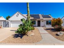 Charming single-story home featuring desert landscaping, solar panels, and a two-car garage at 1042 E Utopia Rd, Phoenix, AZ 85024