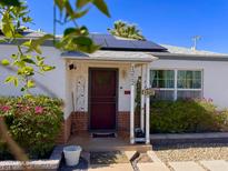Inviting front door with solar panels and landscaped yard, showcasing curb appeal and energy efficiency at 1222 E Almeria Rd, Phoenix, AZ 85006
