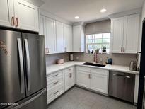 Modern kitchen featuring stainless steel appliances, white cabinetry, and a stylish backsplash at 1222 E Almeria Rd, Phoenix, AZ 85006