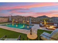 Inviting backyard with pool, fire pit, and desert views, perfect for outdoor entertaining at 16417 W Fawn Dr, Goodyear, AZ 85338