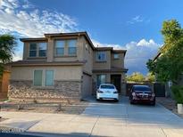Charming two-story home featuring a stone facade, well-manicured landscaping, and a two-car driveway at 17344 W Adams St, Goodyear, AZ 85338