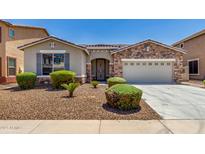 Charming single-story home with a stone accent facade, low-maintenance landscaping, and a two-car garage at 18041 W Ivy Ln, Surprise, AZ 85388