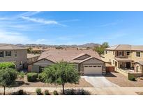 Charming single-Gathering home featuring neutral-toned stucco, well-maintained landscaping, and a two-car garage at 19009 E Reins Rd, Queen Creek, AZ 85142