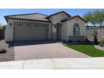Charming single-story home featuring a well-manicured yard and a brick-paved driveway leading to a two-car garage at 24146 N 162Nd Ln, Surprise, AZ 85387