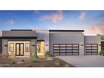 Modern home featuring a two-car garage with glass door, stone accents and desert landscaping at dusk at 24651 N 127Th Way # 30, Scottsdale, AZ 85255
