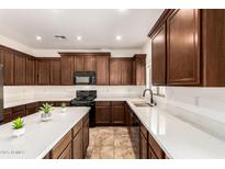 Spacious kitchen boasts rich wood cabinetry, sleek countertops, and modern appliances at 283 W Tahiti Dr, Casa Grande, AZ 85122