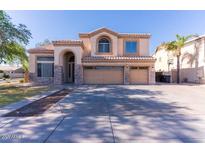 Traditional two-story home with stucco exterior, stone accents, a two-car garage, and a well-kept lawn at 2880 E Nunneley Rd, Gilbert, AZ 85296