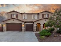 Charming two-story home featuring a three-car garage, stone accents, and lush landscaping at 3715 W Teresa Dr, New River, AZ 85087