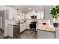Bright kitchen with white cabinets, stainless steel appliances, wood countertops, and a modern design at 39 N Maple St, Mesa, AZ 85205
