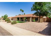 Charming single-story home featuring a tile roof, desert landscaping, and an inviting front porch at 410 E Beck Ln, Phoenix, AZ 85022