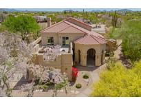 Stunning exterior view of a tan home with a red tiled roof and lush desert landscaping at 4727 E Rancho Caliente Dr, Cave Creek, AZ 85331