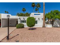 Charming home showcasing desert landscaping with palm trees and a light-colored facade at 4950 N 78Th St, Scottsdale, AZ 85251