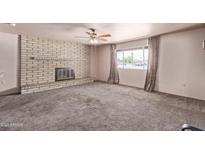 Spacious living room with a brick fireplace and large window providing ample natural light at 501 E Hill Dr, Avondale, AZ 85323