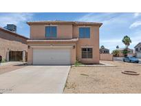 Two-story home showcasing a neutral color palette, tiled roof, and a two-car garage at 5401 N 104Th Dr, Glendale, AZ 85307