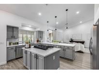 Modern kitchen featuring gray cabinets, quartz countertops, a gas cooktop, and stainless steel appliances at 8449 W Rockwood Dr, Peoria, AZ 85382