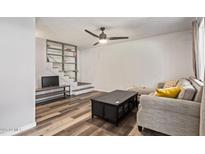 Comfortable living room with ceiling fan, unique staircase with decorative tile, and stylish wood flooring at 8538 E Portland St, Scottsdale, AZ 85257