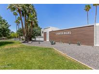 Community front entrance with lush landscaping, featuring desert plants, palm trees, and a sign reading Casita Real at 8552 E Indian School Rd # B, Scottsdale, AZ 85251