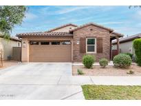 Charming single-story home boasts brick accents, a two-car garage, and desert landscaping for easy maintenance at 9831 E Tupelo Ave, Mesa, AZ 85212