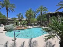 A luxurious pool surrounded by palm trees and rock features, perfect for relaxation and entertainment at 11680 E Sahuaro Dr # 2011, Scottsdale, AZ 85259