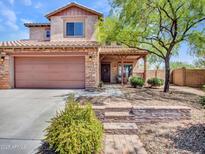Charming two-story home features a covered front porch, desert landscaping, and a two-car garage at 12706 W Pasaro Dr, Peoria, AZ 85383