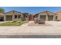 Charming home featuring desert landscaping, a gated entry, and dual two-car garages at 14538 W Sheridan St, Goodyear, AZ 85395