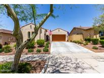 Charming single-story home featuring a tile roof, mature landscaping, and a spacious driveway leading to a two-car garage at 20962 W Thomas Rd, Buckeye, AZ 85396